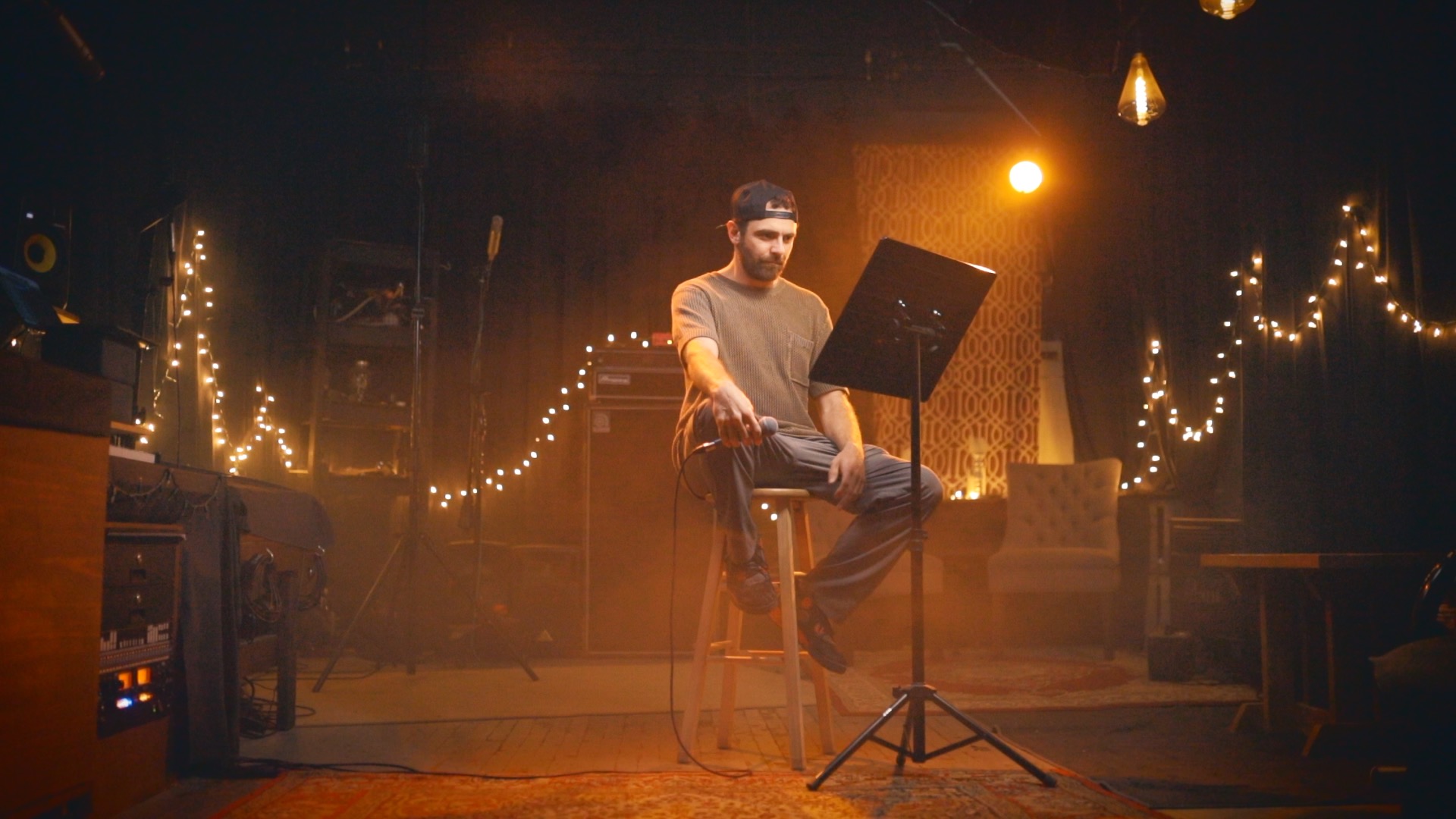 Bergdawg seated on stool in warm studio lights