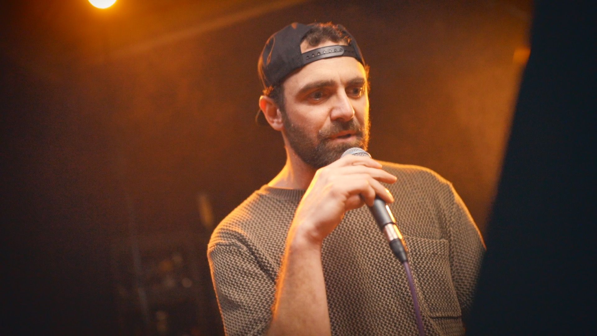 Bergdawg holding microphone near music stand